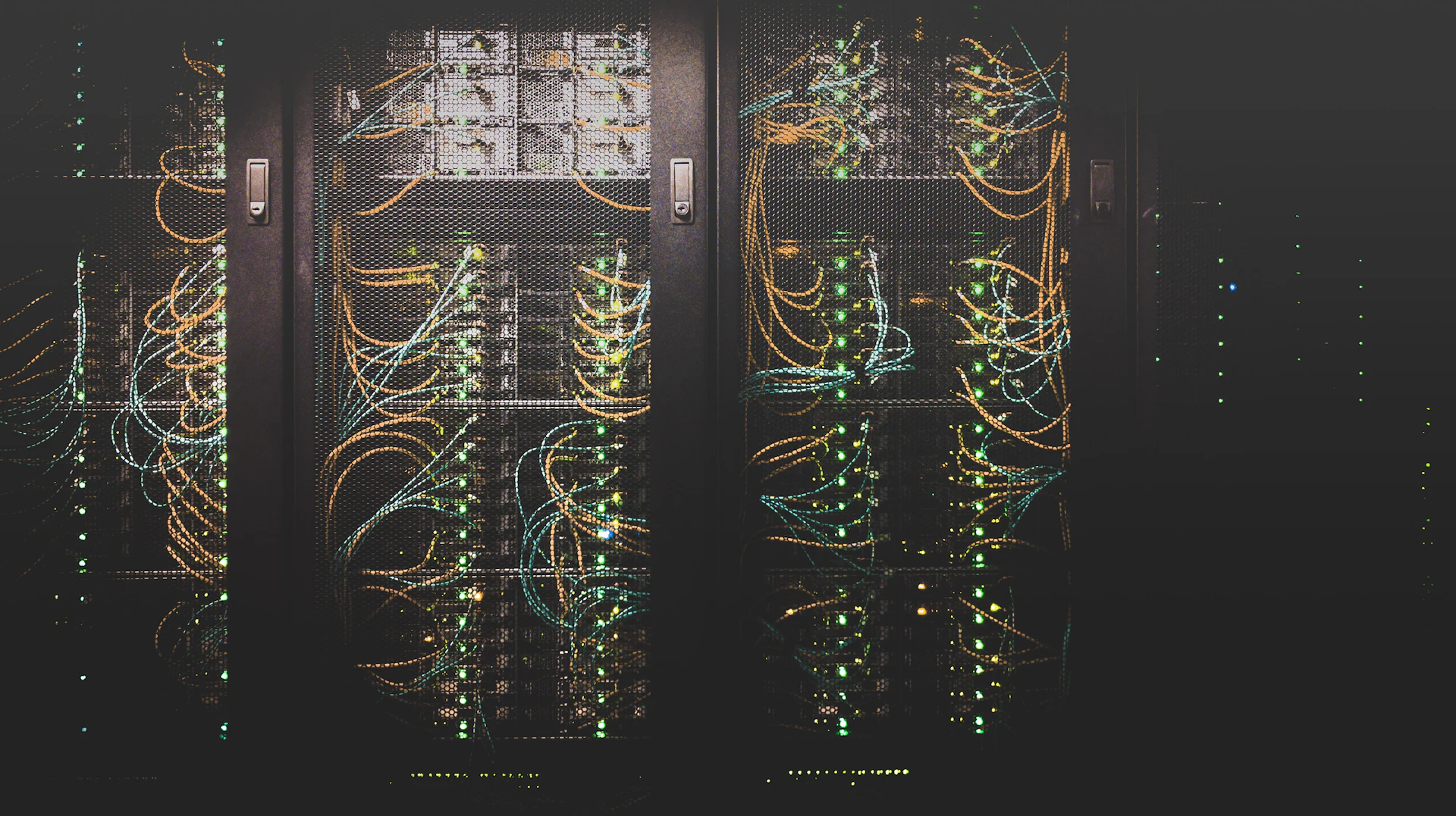 Corredor de data center com racks e cabeamento estruturado em baixa luz